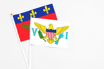 United States Virgin Islands and Guadeloupe stick flags on white background. High quality fabric, miniature national flag. Peaceful global concept.White floor for copy space.