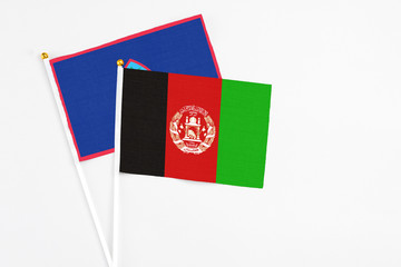 Afghanistan and Guam stick flags on white background. High quality fabric, miniature national flag. Peaceful global concept.White floor for copy space.