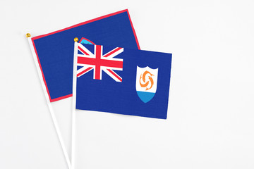Fototapeta premium Anguilla and Guam stick flags on white background. High quality fabric, miniature national flag. Peaceful global concept.White floor for copy space.