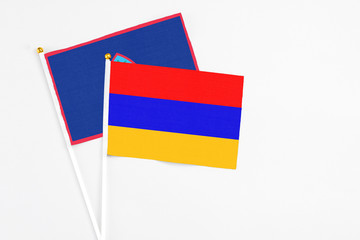 Armenia and Guam stick flags on white background. High quality fabric, miniature national flag. Peaceful global concept.White floor for copy space.