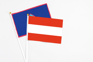Austria and Guam stick flags on white background. High quality fabric, miniature national flag. Peaceful global concept.White floor for copy space.