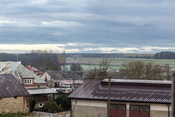  A view of the village from a bird's flight. Roofs of residential buildings, barns, equipment. The forest in the background. Podlasie. Poland.