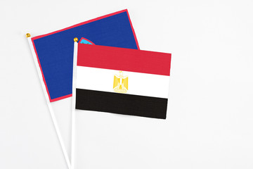 Egypt and Guam stick flags on white background. High quality fabric, miniature national flag. Peaceful global concept.White floor for copy space.