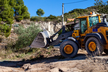 Obraz premium .Excavator shovel clearing dirt and tree roads from a natural disaster