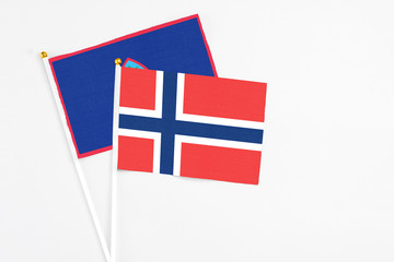 Obraz premium Norway and Guam stick flags on white background. High quality fabric, miniature national flag. Peaceful global concept.White floor for copy space.