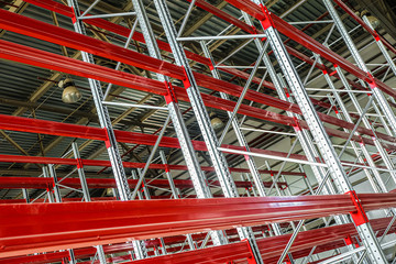 Empty multi-story shelving in industrial warehouse building. Rows of racks.