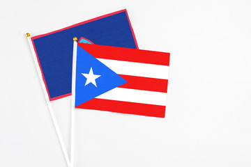Puerto Rico and Guam stick flags on white background. High quality fabric, miniature national flag. Peaceful global concept.White floor for copy space.