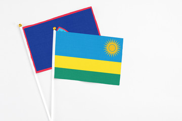 Rwanda and Guam stick flags on white background. High quality fabric, miniature national flag. Peaceful global concept.White floor for copy space.