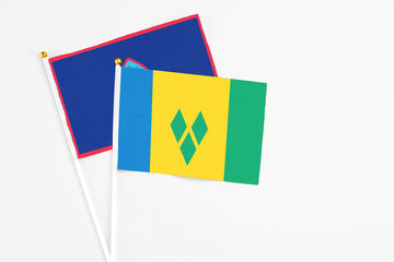 Saint Vincent And The Grenadines and Guam stick flags on white background. High quality fabric,...