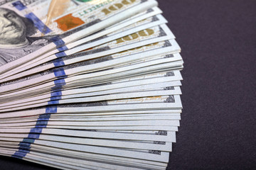 New 100 US dollars 2013 edition banknotes. Stack of one hundred dollar bills on a stone table top.