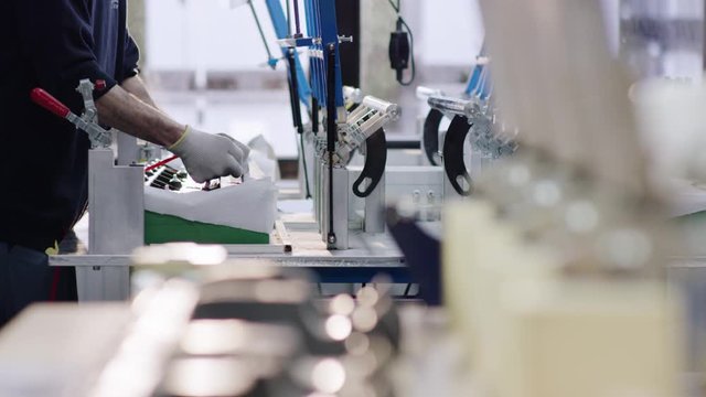 Man works in a big workshop on a car part