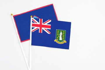 Fototapeta premium British Virgin Islands and Guam stick flags on white background. High quality fabric, miniature national flag. Peaceful global concept.White floor for copy space.