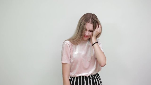 Portrait of woman with closed eyes and covering hand with cheek, like toothache like crying isolated on white wall background in studio. People sincere emotions, lifestyle concept.