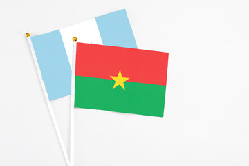 Burkina Faso and Guatemala stick flags on white background. High quality fabric, miniature national flag. Peaceful global concept.White floor for copy space.