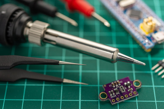 Electronics Development Concept. Hobbies are electronics. Soldering iron and tools on the desktop.
