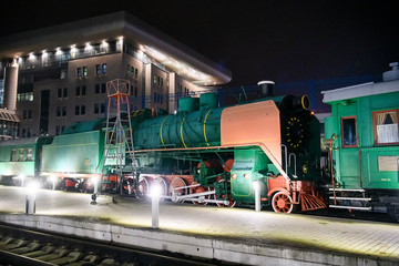 Night view of historical old steam locomotive exhibited in open air Train, Locomotives and Wagons museum. KYIV, UKRAINE. November 2019