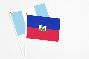Haiti and Guatemala stick flags on white background. High quality fabric, miniature national flag. Peaceful global concept.White floor for copy space.