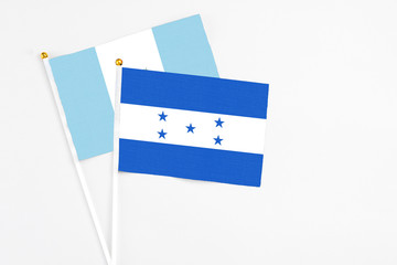Honduras and Guatemala stick flags on white background. High quality fabric, miniature national flag. Peaceful global concept.White floor for copy space.