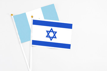 Israel and Guatemala stick flags on white background. High quality fabric, miniature national flag. Peaceful global concept.White floor for copy space.