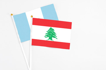 Lebanon and Guatemala stick flags on white background. High quality fabric, miniature national flag. Peaceful global concept.White floor for copy space.