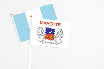 Mayotte and Guatemala stick flags on white background. High quality fabric, miniature national flag. Peaceful global concept.White floor for copy space.