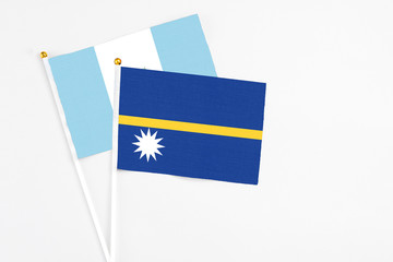 Nauru and Guatemala stick flags on white background. High quality fabric, miniature national flag. Peaceful global concept.White floor for copy space.