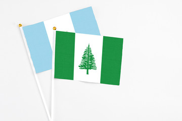 Norfolk Island and Guatemala stick flags on white background. High quality fabric, miniature national flag. Peaceful global concept.White floor for copy space.
