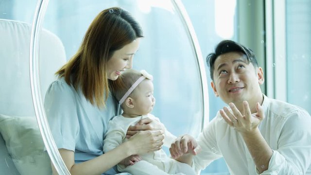Young Chinese Asian family happy watching bubbles floating