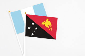 Papua New Guinea and Guatemala stick flags on white background. High quality fabric, miniature national flag. Peaceful global concept.White floor for copy space.