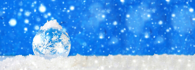 Fototapeta na wymiar Christmas ball on a background of snowflakes. Christmas or New Year card, bokeh effect.