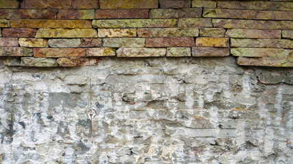 ruined wall of stone blocks of different colors