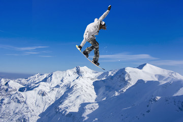 Fototapeta na wymiar Skier Snowboarder jumping through air with sky in background