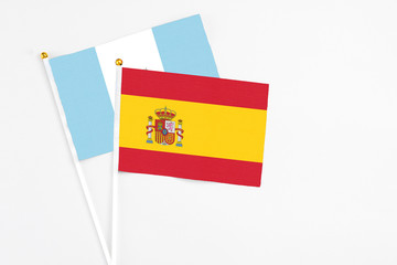 Spain and Guatemala stick flags on white background. High quality fabric, miniature national flag. Peaceful global concept.White floor for copy space.