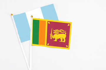 Sri Lanka and Guatemala stick flags on white background. High quality fabric, miniature national flag. Peaceful global concept.White floor for copy space.