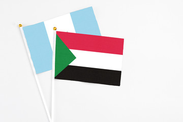 Sudan and Guatemala stick flags on white background. High quality fabric, miniature national flag. Peaceful global concept.White floor for copy space.