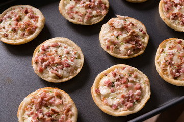 Uncooked mini pizza on plate, raw.