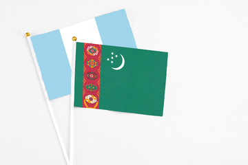 Turkmenistan and Guatemala stick flags on white background. High quality fabric, miniature national flag. Peaceful global concept.White floor for copy space.