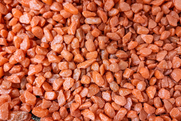 Decorative drainage for plants. Small red-orange stones. Red background. The texture of the stone. Copy space