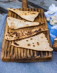 Chapati - Indian traditional tandoori naan bread on wooden board.