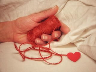 mano femminile con spago rosso e cuore