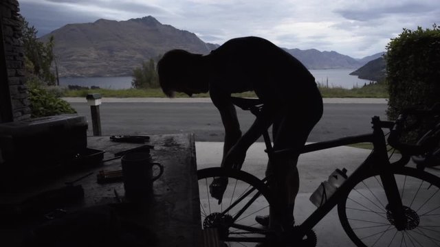 Silhouette of male cyclist doing service Lake Wakatipu