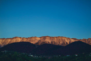 Beautiful sunrise golden hour light over the Piatra Craiului snowy peak in Romania