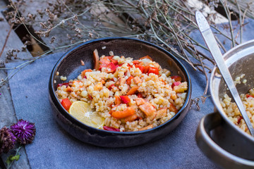 Cooked bulgur wheat mediterranean salad with fresh vegetables and lemon. Tabbouleh - Turkish, Arabian, Levantine traditional pilaf food.