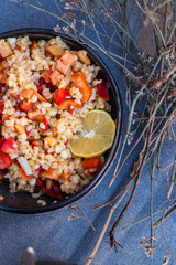 Cooked bulgur wheat mediterranean salad with fresh vegetables and lemon. Tabbouleh - Turkish, Arabian, Levantine traditional pilaf food.