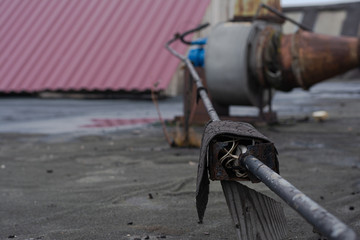 junction box for connecting wires to each other, without a cover on the street. the box is covered with roofing material on top. electrical safety violation