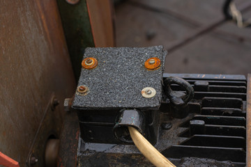 Electric motor on the covers of the plant. Terminal box. Instead of a cover, a roofing material mounted on a bolted connection was used. The manifestation of ingenuity in a difficult situation