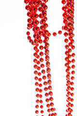 Red christmas beads on marble background. Christmas frame. Line of red beads garland on a white background. Top view. Copy space