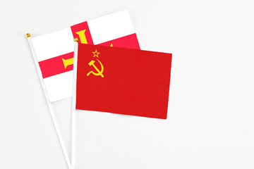 Soviet Union and Guernsey stick flags on white background. High quality fabric, miniature national flag. Peaceful global concept.White floor for copy space.