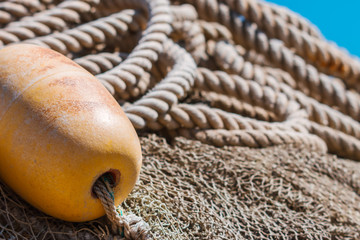 Old fishing nets with weathered buoy and rope.