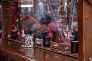 Christmas fair in Europe. Abstract background of blurry Christmas lights, New Year celebration decorations and defocused people silhouettes. Reflection in framed window